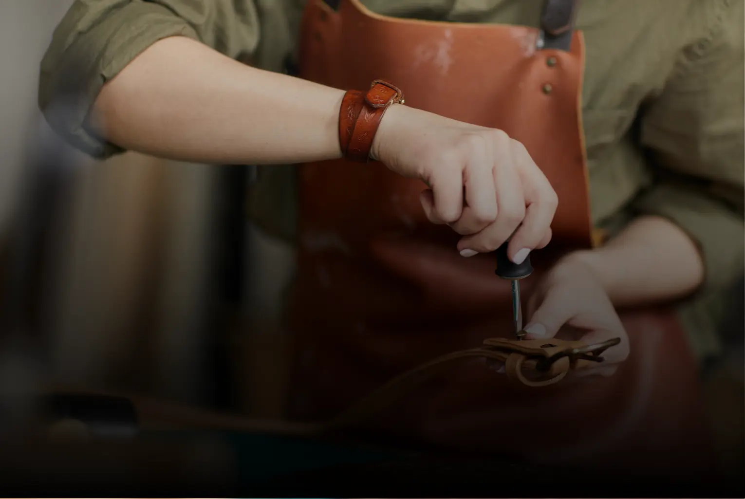 Des mains d'homme en train de viser le ceinturon lors d'un ateier cuir-Pau de Cuir-Maroquinerie artisanale