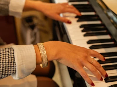Manchette en acier et cuir doré au poignet d'une femme qui joue du piano-Pau de Cuir-Pau-Maroquinerie artisanale