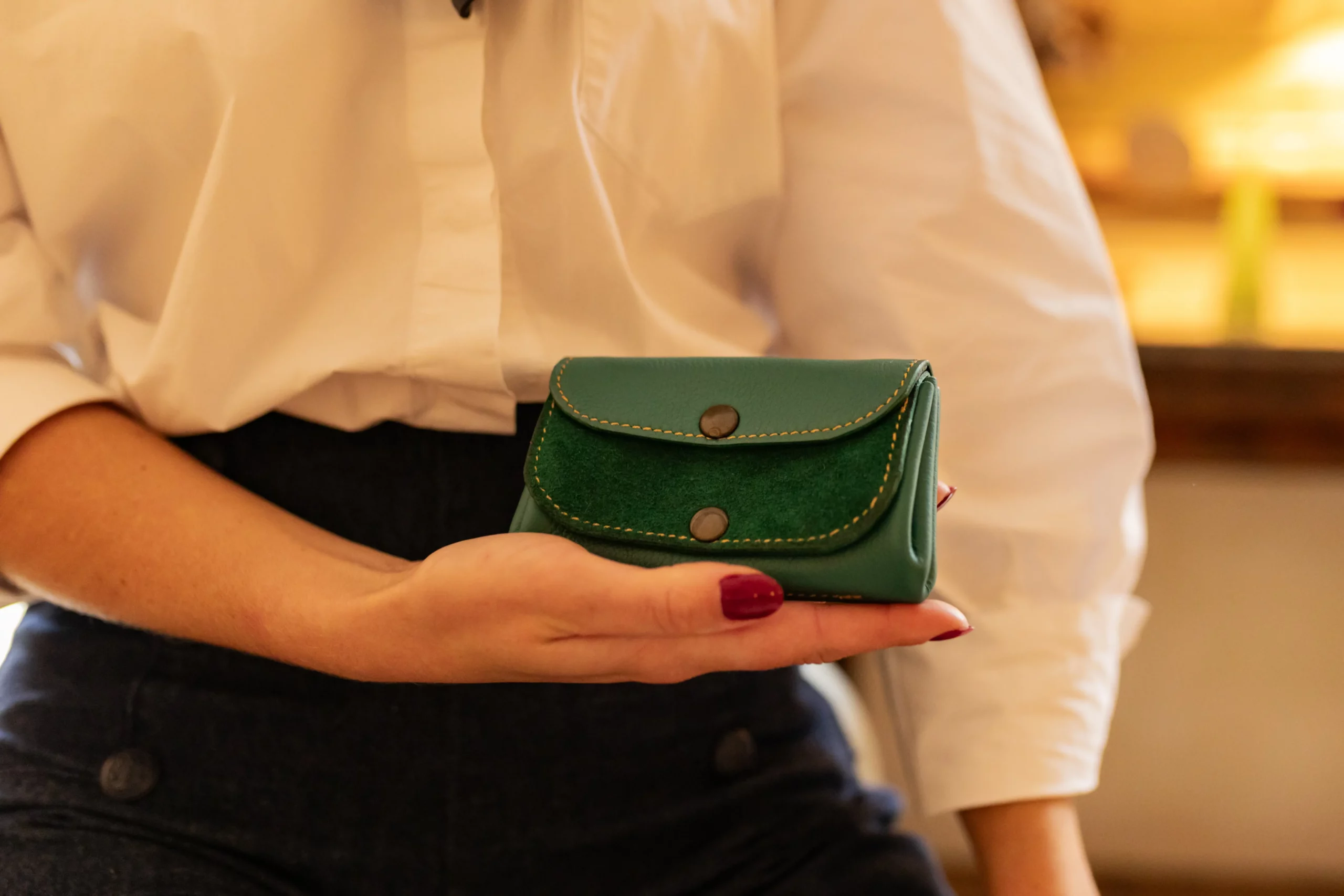 Porte-monnaie Le p'tit sucré vert sapin, bi texture posé dans la main d'une femme-Pau de Cuir-Pau-Maroquinerie artisanale