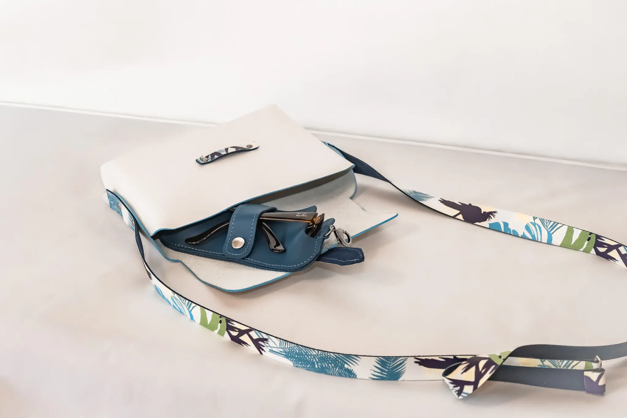 Sac origami jungle blanc avec anse en cuir colorée ouvert avec un étui à lunettes à l'intérieur-Pau de Cuir-Pau-Maroquinerie artisanale