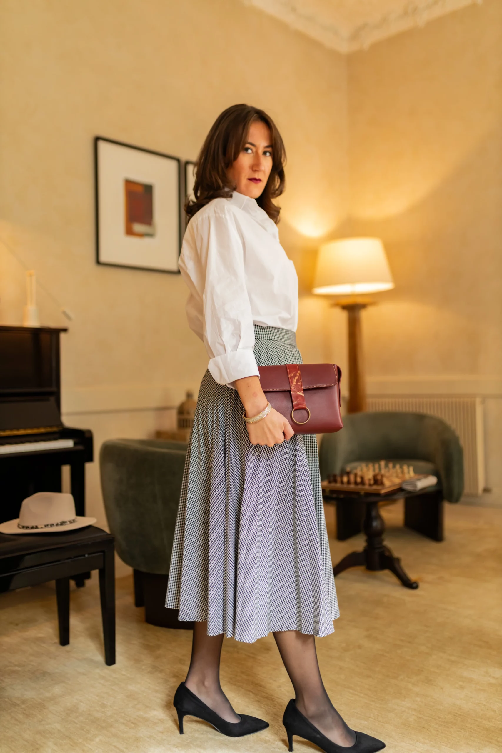 Sac en cuir bordeaux tenu en pochette à la main par une jeune femme élégante-Pau de Cuir-Pau-Maroquinerie artisanale