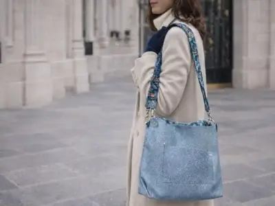 Jeune femme en manteau beige portant le Sac cabas en cuir bleu gris motif galuchat avec poche plate sur le devant-Pau de Cuir-Pau-Maroquinerie artisanale