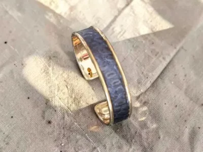 Manchette largeur moyenne laiton et cuir imprimé serpent bleu nuit-posé sur un coupon de lin naturel beige -pau-de cuir-pau- maroquinerie artisanale