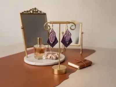 Boucles d'oreilles en cuir prisme violet et feuille posées sur un présentoir en laiton doré- Pau de Cuir-Maroquinerie artisanale - Pau